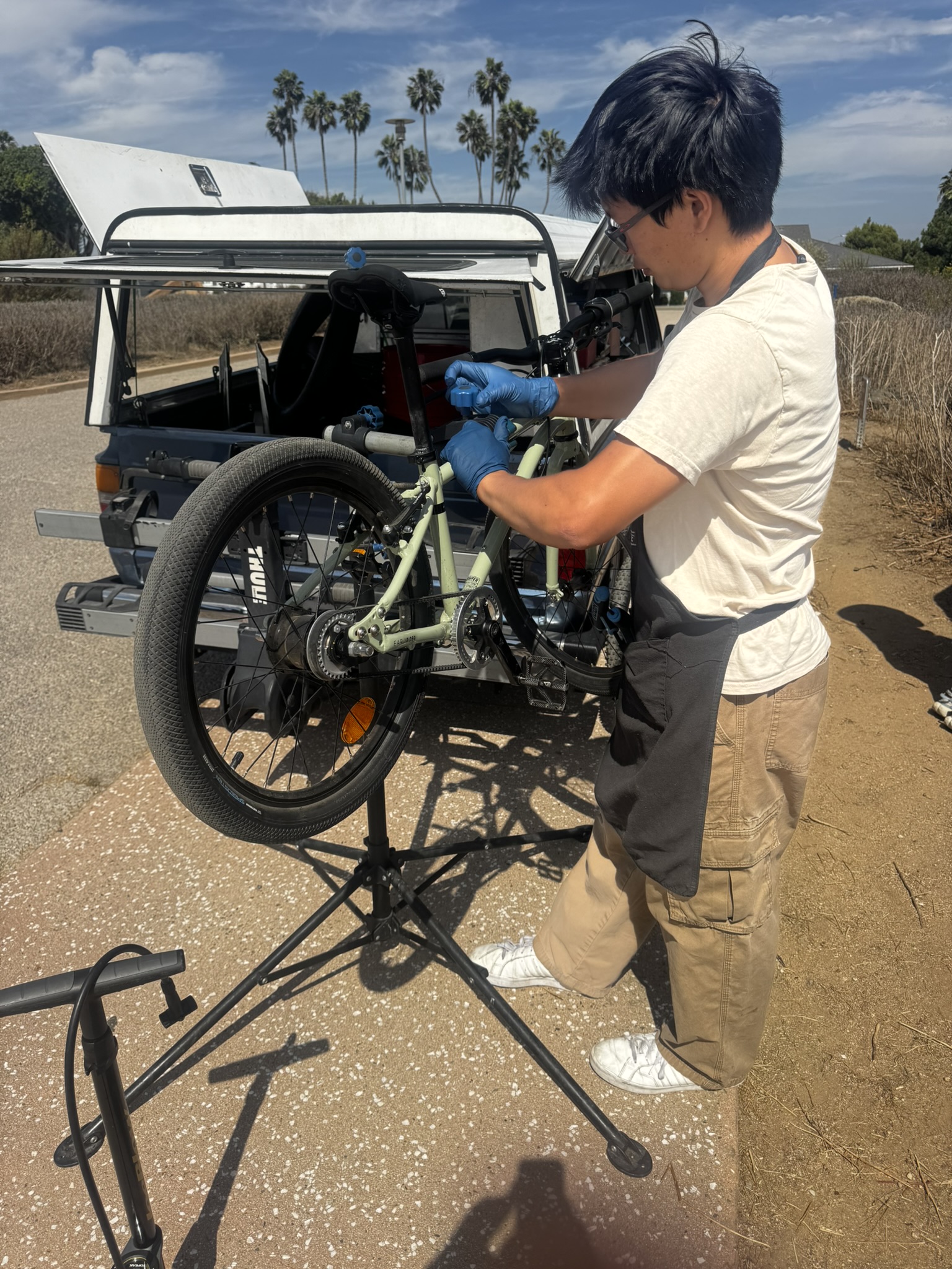 Tuning up a kids' bike on the stand next to the truck before heading out